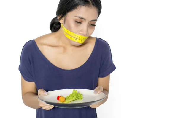 Magere vrouw met salade en meetlint — Stockfoto