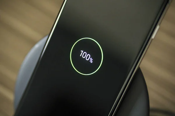 Smartphone placed on a wireless fast charger — Stock Photo, Image