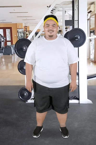 Uomo grasso sorridente in piedi nel centro della palestra — Foto Stock