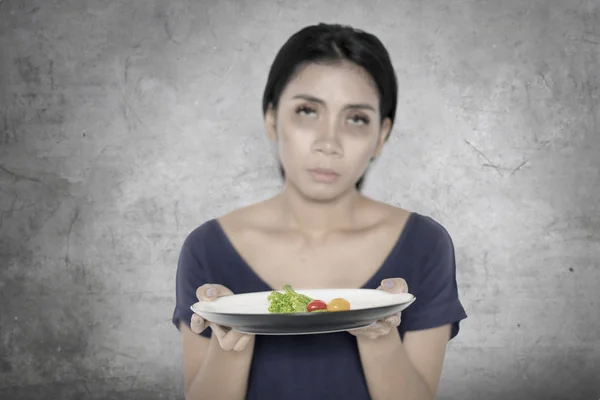 Femme malsaine tient une petite portion de salade — Photo