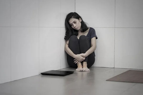 Нездорова жінка сидить з ваговими вагами — стокове фото