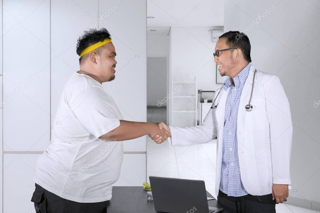 Fat man shaking hands with his doctor on clinic