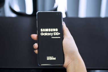 Genç kadın bir Samsung Galaxy S10 + telefon tutar