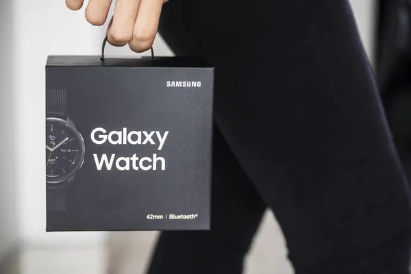 Ung kvinna som bär en låda med Galaxy Watch — Stockfoto