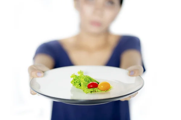 Young woman holds small portion salad on studio — Stock Photo, Image