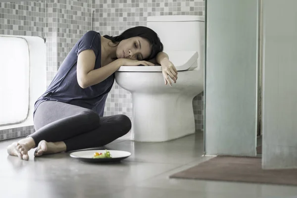 Mujer joven se ve cansada después de vomitar — Foto de Stock