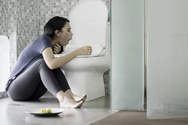 Mujer joven vomitando en el baño después de comer — Foto de Stock