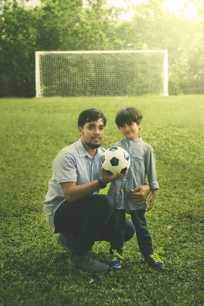 サッカーのフィールドに彼の息子を持つアジア男 — ストック写真