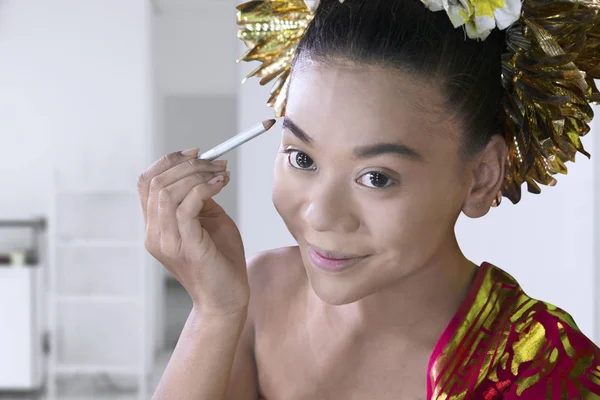 Beautiful dancer doing makeup with cosmetic pencil — Stock Photo, Image