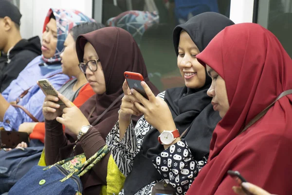 Mitfahrerinnen nutzen Smartphone in Jakarta — Stockfoto