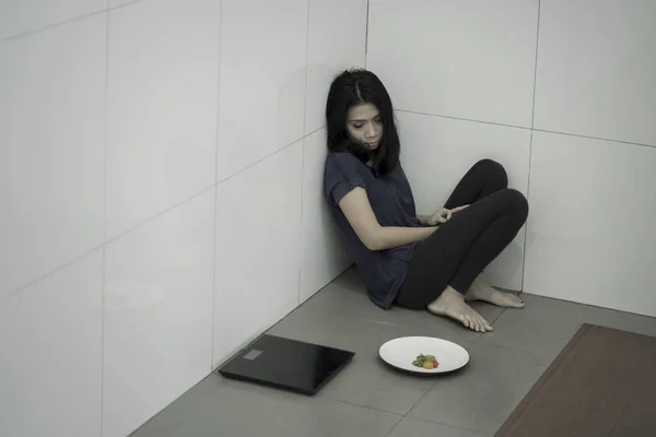 Smal anorektisk kvinna med sallad och skalor — Stockfoto