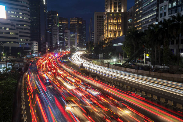 Top view of trail lights from rush traffic on the road at night time in Jakarta downtown