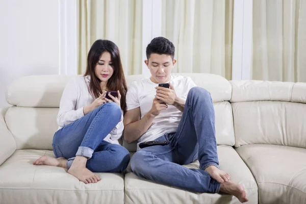 Jeune couple utilisant un smartphone à la maison — Photo