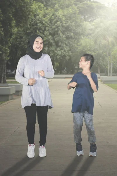 快乐的孩子和他的母亲在公园里慢跑 — 图库照片