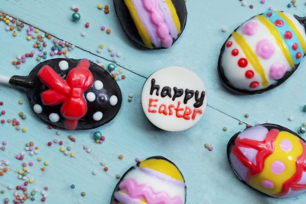 Feliz texto de Pascua con dulces de chocolate de colores —  Fotos de Stock