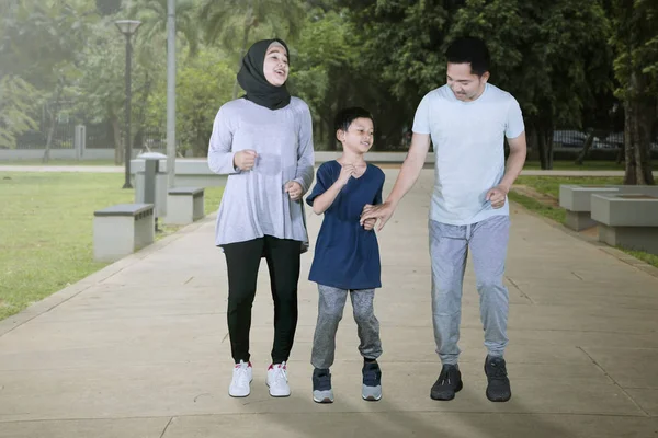 Muslimische Eltern laufen mit ihrem Sohn im Park — Stockfoto