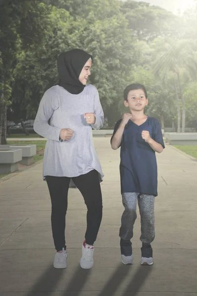 Mulher muçulmana correndo com seu filho no parque — Fotografia de Stock