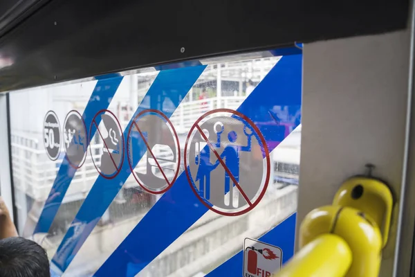 Panneaux d'avertissement sur une fenêtre de bus Transjakarta — Photo