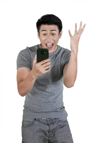 Молодий чоловік висловлює успіх під час утримання телефону — стокове фото