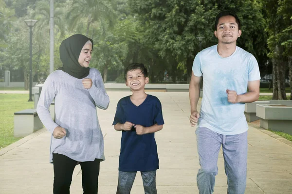 Jonge ouders joggen met hun zoon in het Park — Stockfoto
