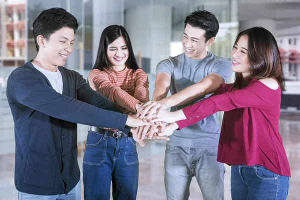 Asiáticos universitarios muestran unidad mediante la unión de manos —  Fotos de Stock