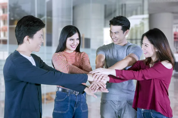 Vier College studenten bundelen handen samen — Stockfoto