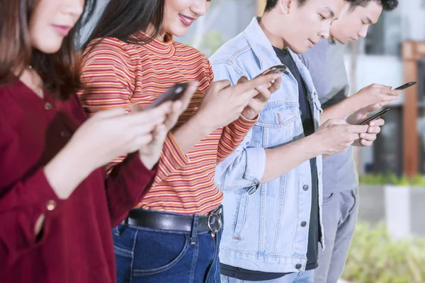 Grupo de estudantes universitários usando telefones ao ar livre — Fotografia de Stock