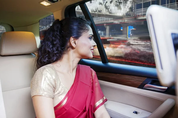 Femme indienne regarde par la fenêtre d'une voiture — Photo