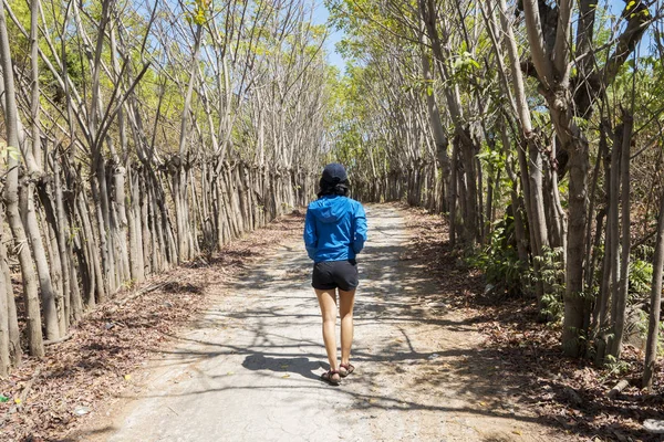 Giovane donna solitaria cammina nella foresta tropicale — Foto Stock