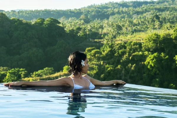Mujer joven disfruta de la vista a la montaña en la piscina — Foto de Stock