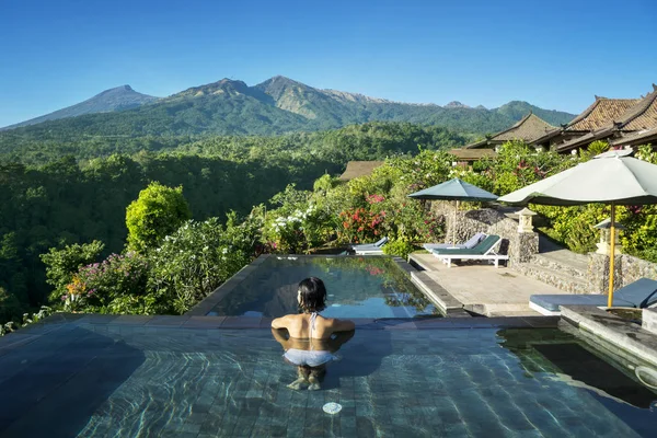 Jeune femme relaxant sur la piscine — Photo