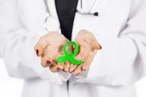 Female doctor hands show a lime green ribbon — Stock Photo, Image