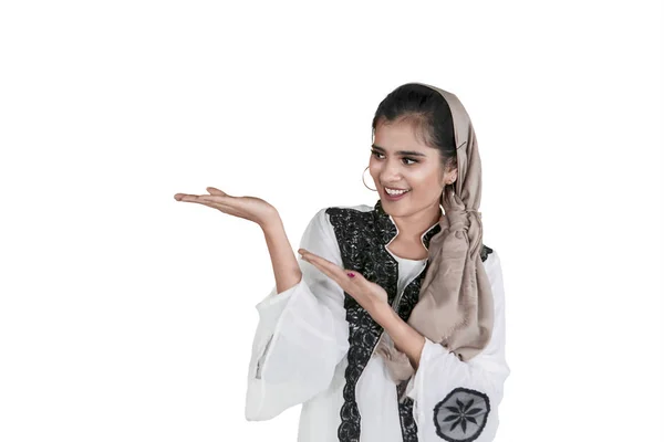 Happy Muslim woman shows something on studio — Stock Photo, Image