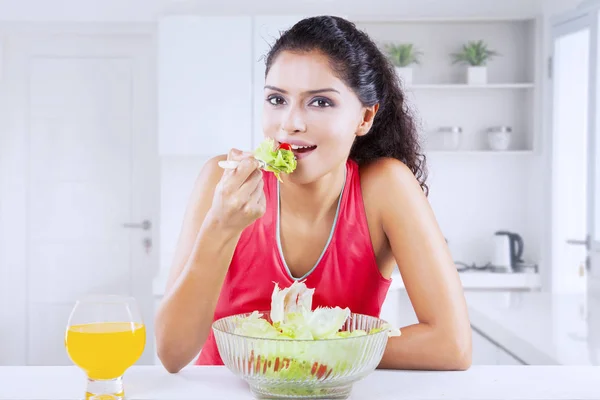 Menina indiana bonita comendo uma tigela de salada em casa — Fotografia de Stock