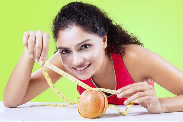 Mujer india joven midiendo manzana fresca — Foto de Stock