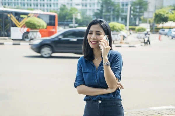 Woman talks on a phone and stand on sidewalk — Stock Photo, Image