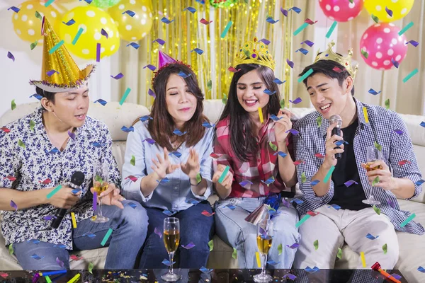 Cheerful young people singing at a birthday party — Stock Photo, Image