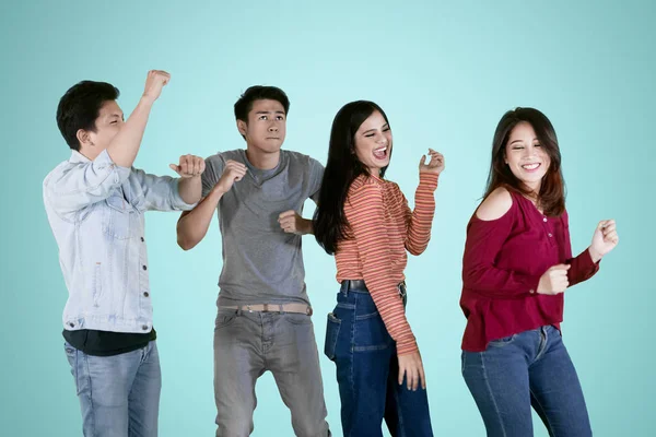 Cuatro estudiantes celebran el éxito bailando en el estudio — Foto de Stock