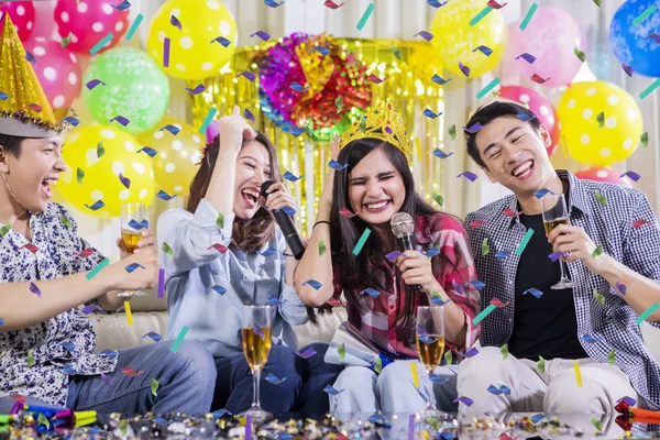 Deux jeunes couples chantent lors d'une fête d'anniversaire — Photo