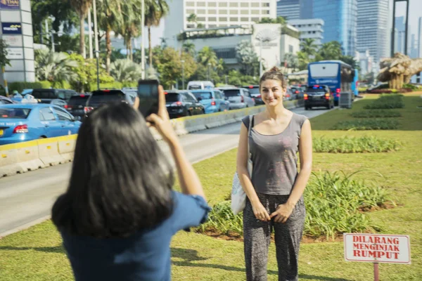 Cakarta'da turistin fotoğrafını çeken kadın — Stok fotoğraf