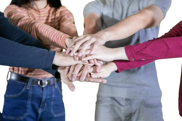 Молодые люди объединяют свои руки в студии — стоковое фото
