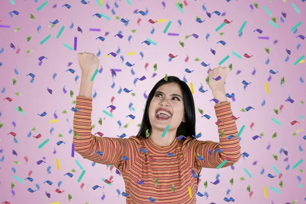 Ung kvinna som uttrycker glädje med konfetti — Stockfoto