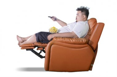 Şişman adam seyretmek televizyon sırasında patlamış mısır yiyor