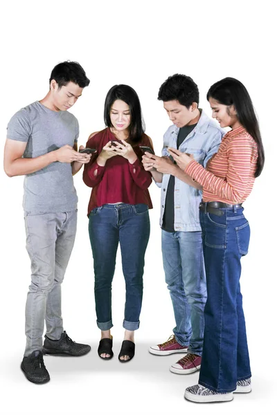 Четверо молодых людей пользуются мобильным телефоном в студии — стоковое фото