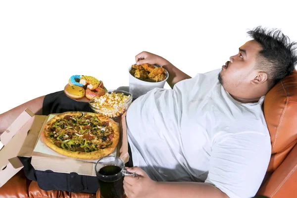 Homem obeso desfrutando de junk foods na cadeira — Fotografia de Stock