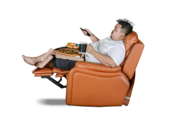 Παχύσαρκος άνθρωπος απολαμβάνει τρόφιμα κατά τη διάρκεια ρολόγια τηλεόραση — Φωτογραφία Αρχείου