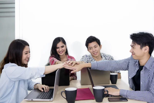 Joven equipo de negocios uniendo sus manos después de una reunión — Foto de Stock