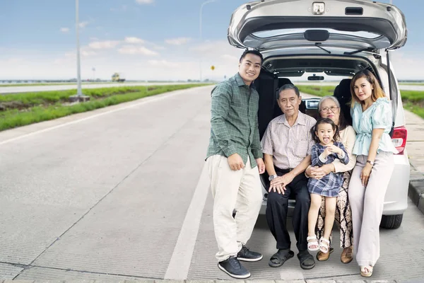 Große Familie sitzt auf dem Kofferraum ihres Autos — Stockfoto
