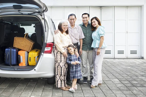 Grande família de pé perto de seu carro na garagem — Fotografia de Stock