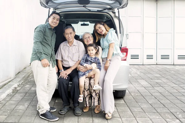 Gran familia feliz sentado en el maletero de su coche —  Fotos de Stock